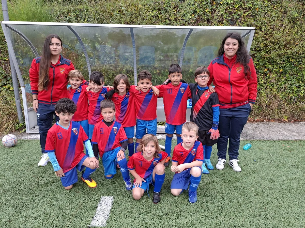 Dos entrenadoras del Campestre con los más pequeños del club delante del banquillo